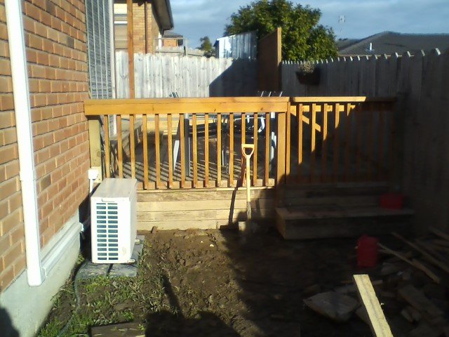 Raised timber deck with balustrade beside a house